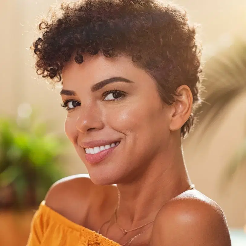 Mulher com cabelo cacheado curto e corte pixie cut
