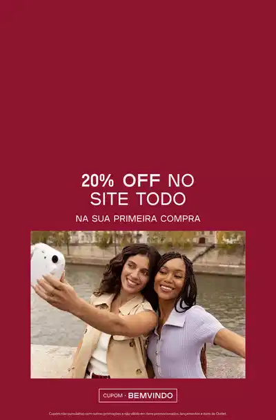 Fundo vermelho intenso com duas mulheres sorrindo e tirando selfie ao lado de um canal. À esquerda, texto em branco: "20% de desconto no site todo na sua primeira compra". À direita, etiqueta com "CUPOM: BEMVINDO". Rodapé com informações legais em texto pequeno.