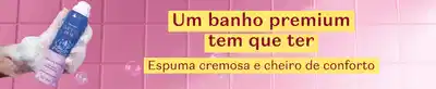 Frasco azul e branco com espuma em fundo roxo e branco e texto contando que um banho premium precisa ter espuma cremosa e cheiro de conforto.
