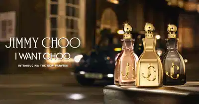 Anúncio de perfume Jimmy Choo I Want Choo, mostrando três frascos de perfume em uma rua à noite.