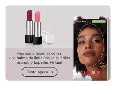 A imagem mostra uma mulher com cabelos cacheados usando um aplicativo de realidade aumentada para experimentar diferentes cores de batons. Ao lado, há dois batons da marca O Boticário, um vermelho e outro rosa. O texto convida o usuário a testar o Espelho Virtual para ver como ficam as cores dos batons em seus lábios.