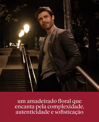 Um homem elegantemente vestido em um ambiente noturno. Um amadeirado floral que encanta pela complexidade, autenticidade e sofisticação.