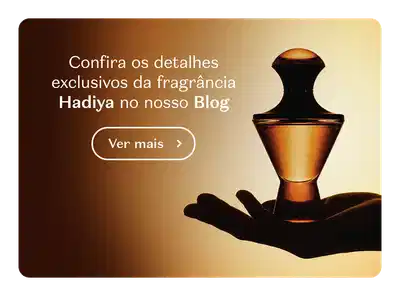 Frasco do Eau de Parfum Hadiya sendo segurado por uma mão. O banner convida a conferir os detalhes exclusivos da fragrância no Blog do Boticário.