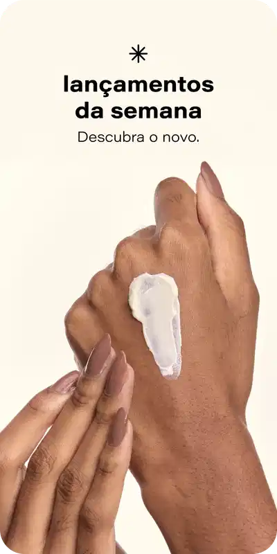 O banner mostra as mãos de uma pessoa aplicando um produto cosmético em sua pele. O texto destaca os "Lançamentos da semana" e convida o leitor a "Descobrir as novidades".
