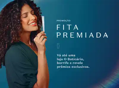 Promoção Fita Premiada. Mulher com cabelo ondulado castanho-avermelhado segurando frasco branco, sorrindo em fundo azul-petróleo. Texto: Vá até uma loja O Boticário, borrife e revele prêmios exclusivos. Ícone de frasco de Body Splash ao lado do texto.