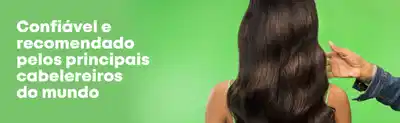 Fundo verde com texto em branco à esquerda dizendo "Confiável e recomendado pelos principais cabeleireiros do mundo". À direita, mulher de costas com cabelo comprido e liso, com uma mão tocando os fios.