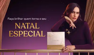 Banner com fundo roxo. Texto em destaque: "Faça brilhar quem torna o seu NATAL ESPECIAL". Mulher de cabelo castanho escuro, usando blusa de gola alta bordô, com a mão apoiada no queixo.