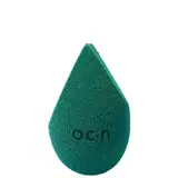 Esponja de maquiagem verde escuro com textura aveludada. Formato de gota com a palavra "Océane" impressa em relevo na superfície.
