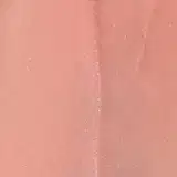 Produto de beleza Vult, um gloss labial líquido com embalagem plástica transparente e tampa preta. A cor predominante é um tom rosado claro, com o nome "Iconic Shine" impresso no rótulo.
