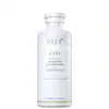 Frasco branco de shampoo da marca Keune Care, com rótulo em letras pretas indicando "Satin Oil Shampoo". O produto é apresentado em embalagem cilíndrica com tampa branca.