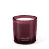 Vela aromática em recipiente de vidro de cor vinho com rótulo "Casa 214 o Boticario" em letras douradas. O recipiente possui formato cilíndrico e a vela em seu interior parece ser de cor clara.