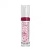 Frasco cilíndrico de vidro transparente com tampa branca tipo pump e tampa protetora. Produto rosa claro contendo pequenos pontos vermelhos. Rótulo transparente em em letras brancas e rosa pink.