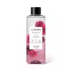 O produto apresentado é um óleo bifásico corporal da linha Instance Rosa Absoluta. O frasco é transparente, com um rótulo branco contendo o nome da marca, da linha e do aroma. A embalagem possui uma tampa preta e contém 200 ml do produto.