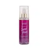 A imagem mostra o Body Splash em uma embalagem com cores roxo, rosa e dourado, apresentando o logotipo Kiss New York. A tampa é transparente e traz um detalhe dourado na válvula spray.