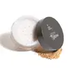 Pote de pó solto translúcido aberto onde se vê uma tampa interna branca com pequenos furinhos e uma tampa externa preta com logotipo Tô no Glow em destaque e um pouco de produto bege espalhado do lado de fora da embalagem