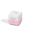 Produto de beleza em formato cúbico com tampa arredondada. Embalagem branca com detalhes em rosa claro. Apresenta um desenho estilizado de uma vaca na parte superior branca. A embalagem tem um design minimalista, com poucas cores e elementos simples.