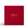 A imagem mostra uma caixa de embalagem quadrada na cor vermelha. No centro da caixa, está impresso o logotipo "O.U.i" em dourado. A cor vermelha vibrante e o acabamento de qualidade transmitem uma sensação de sofisticação e luxo.
