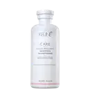 Frasco branco da linha Care da Keune, contendo Shampoo Color Brillianz para proteção de cabelos coloridos. Rótulo com nome do produto e informações sobre sua função de proteger a cor dos cabelos.