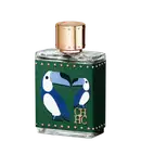A imagem mostra um frasco de perfume, em formato retangular e feito de vidro transparente, com uma tampa dourada com detalhes e uma capa, cor verde, que cobre o frasco, com detalhes dourados e o desenho de dois pássaros azuis e a logo da marca em dourado.