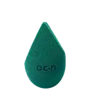 Esponja de maquiagem verde escuro com textura aveludada. Formato de gota com a palavra "Océane" impressa em relevo na superfície.