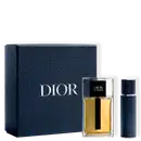 Caixa preta com logotipo Dior em relevo, contendo um frasco de perfume Dior Homme com tampa preta e um frasco de desodorante Dior Homme em fundo preto.