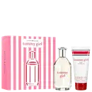 Conjunto Tommy Girl da Tommy Hilfiger com frasco de perfume transparente, loção corporal em tubo branco e rosa, e caixa de embalagem rosa com listras brancas e vermelhas.