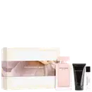 Kit Narciso Rodriguez For Her contendo: caixa com estampa floral em tons rosa e bege, frasco de eau de parfum rosa claro, loção corporal em tubo preto e miniatura de perfume translúcida.