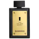Frasco de perfume preto com painel frontal dourado exibindo o texto "The Golden Secret" e "Banderas" em letras douradas. O frasco possui um design elegante e minimalista, com um pequeno orifício no centro.