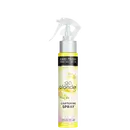 Embalagem plástica amarela com borrifador. O rótulo exibe o logotipo John Frieda em preto, o nome do produto "Go Blonder Lightening Spray".