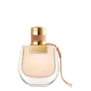 Perfume em frasco de vidro transparente com formato arredondado. A tampa é dourada com detalhes em couro rosé. O nome "NOMADE" está gravado em letras douradas na parte superior da tampa. O líquido dentro do frasco é de uma tonalidade bege claro.