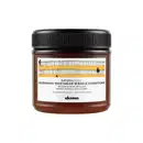 Frasco de condicionador de cabelo Naturaltech da Davines, com tampa preta e rótulo com informações sobre o produto, que promete nutrir e reparar cabelos secos e quebradiços.