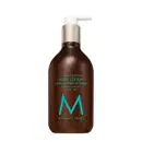 Frasco de loção corporal Moroccanoil com design elegante em tons de marrom e azul. Rótulo indica "Fragrance Originale Body Lotion" com ingredientes de argan e aloe.