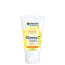Frasco branco de protetor solar facial Garnier SkinActive com fator de proteção solar 30, contendo vitamina C, com acabamento uniforme e mate, conforme indicado no rótulo.