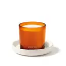 Vela perfumada da marca Casa 214 Vanilla Sublime em recipiente laranja e vela branca aromatizada acompanhada de um suporte para velas na cor branca.