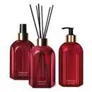 Três vidros vermelhos da marca Casa 214 Gardênia Imperial: um difusor de ambientes com varetas, um sabonete líquido com bico dosador preto e um aromatizador de ambientes com válvula spray preta.