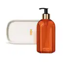 Vidro laranja com detalhe dourado e tampa dosadora preta contendo 400ml de sabonete líquido Casa 214 Vanilla Sublime e uma bandeja de lavabo branca com logo da marca O Boticário em dourado.