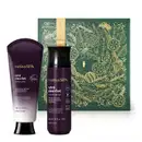 Imagem do Combo Nativa Spa Uva Merlot com uma bisnaga preta e branca com tampa preta de loção corporal, um frasco preto com letras douradas de body splash e uma caixa presenteável verde com fita e estampa douradas.