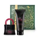 Imagem do Combo Her Code Clímax com o icônico vidro preto em formato de cadeado do Eau de Parfum, bisnaga preta com letras rosa metálico da loção corporal da mesma linha e uma caixa presenteável verde com fita e estampa douradas.