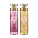 Imagem de dois frascos de body splash Dream,, sendo um com rótulo em tons de roxo da linha Amor no Ar e outro com rótulo em tons de dourado da linha Céu de Baunilha. Ambos recipientes são de vidro, com tampa transparente e válvula spray dourada.