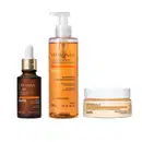 Imagem de três produtos de cuidados com a pele da marca Botik: sérum de vitamina C em frasco marrom com conta-gotas, gel de limpeza facial em embalagem transparente e conteúdo laranja e creme hidratante facial em um pote branco com detalhes laranja.