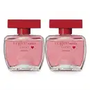 Dois frascos de item de perfumaria da marca Coffee Woman Lucky lado a lado, com embalagem de vidro transparente contendo líquido rosado e tampa vermelha, rótulo com texto em vermelho e desenho de um coração vermelho.