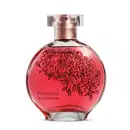 O frasco de vidro tem um formato arredondado e é feito de vidro transparente, com um bocal de metal rosado. O líquido dentro do frasco tem uma cor vermelha vibrante. Na parte frontal do frasco, há um desenho decorativo de rosas vermelhas estilizadas.