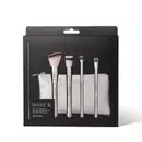 Kit de pincéis de maquiagem Make B. Silver Essentials em embalagem preta contendo um estojo prateado e quatro pincéis com cabos prateados e ponta de cerdas bicolores e macias. O nome da marca está gravada em todos os itens.