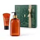 Caixa verde com detalhes dourados e dois itens da marca Casa 214 Vanilla Sublime, sendo uma bisnaga laranja com letras douradas e tampa preta de creme hidratante de mãos e um vidro laranja com bomba dosadora preta de sabonete líquido.