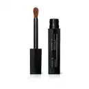 Frasco preto de corretivo líquido da marca Make B. Retinol³ H+ aberto e tampa com aplicador visível na cor preta com ponta em espuma aveludada na cor do produto.