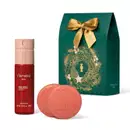 Conjunto de item de perfumaria Floratta Red, composto por frasco de spray corporal vermelho e duas barras de sabonete em formato redondo na cor coral, acompanhados de caixa verde com laço dourado e ilustração natalina dourada.