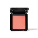 Embalagem preta de blush compacto da marca Make B. aberta, com formato quadrado, e dentro, vemos o produto de tonalidade coral vibrante.