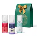 Três frascos de itens de mini body splashes da marca Cuide-se Bem, sendo um da fragrância Morango e Leite (vermelho), outro da fragrância Nuvem (azul claro) e o terceiro da fragrância Boa Noite (lilás). Acompanha caixa de presente verde com laço dourado.