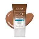 Bisnaga de protetor solar facial fluido com cor da marca Boti Sun com FPS 70, nas cores branca e marrom com indicação de cores variadas no rótulo e um pouco de produto na cor marrom espalhada por trás da embalagem.