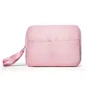 Imagem de uma nécessaire rosa clara com puxador. A bolsa tem vários compartimentos e um zíper na parte frontal. Não há nenhum texto ou rótulo visível na imagem.
